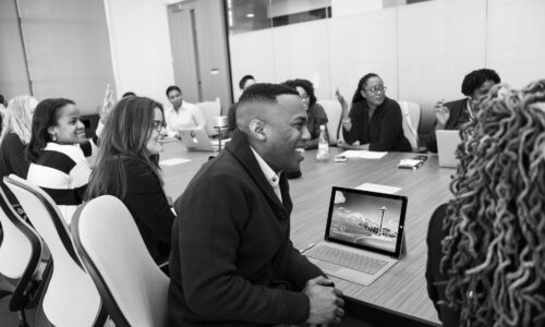 group of people sitting in conference table laughing