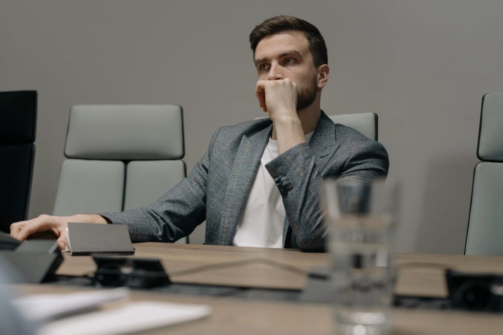 a man in a gray blazer thinking