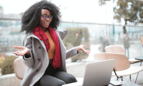 cheerful surprised woman sitting with laptop