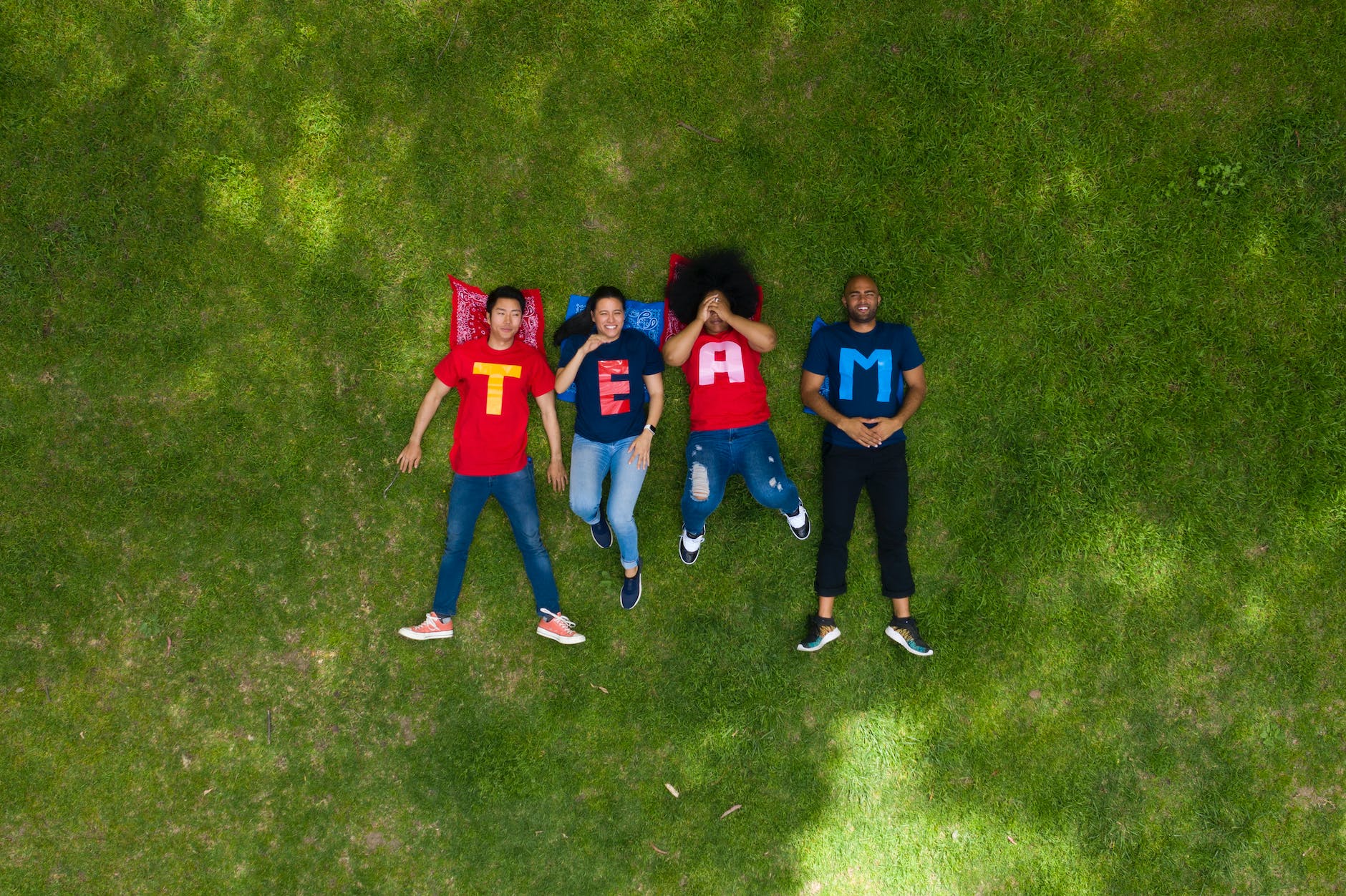 people lying down on green grass